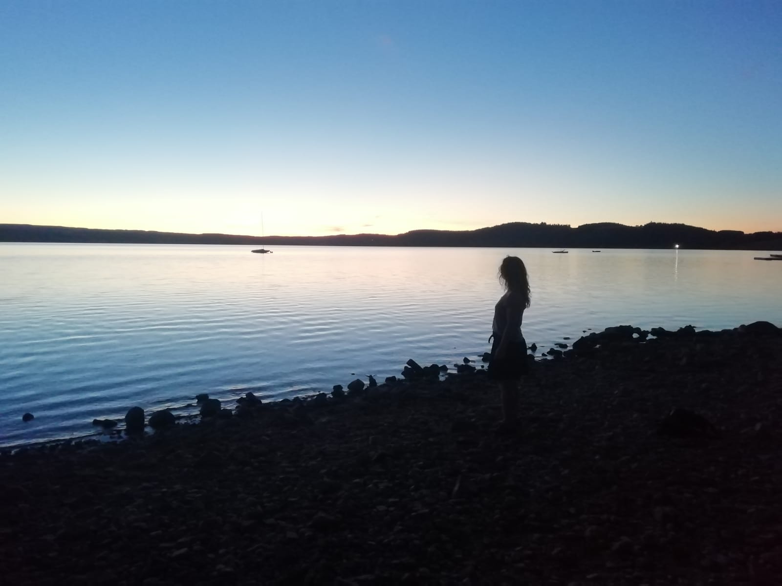 Laëtitia Campi, praticienne de Reiki Tao Tö Qi, face à un lac au coucher du soleil