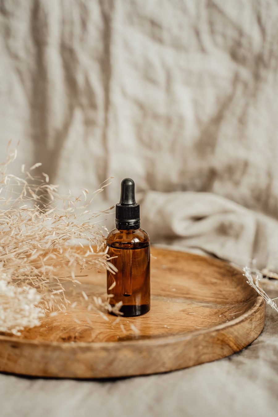 Flacon d’huile essentielle sur un plateau de bois, huiles du Massage Sensoriel Combiné à Castres et Saubens