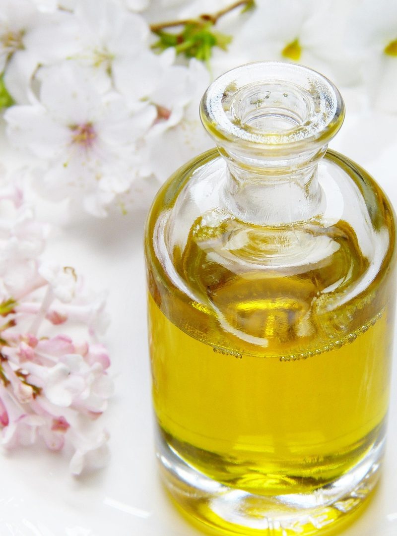 Flacon d’huile de massage et fleurs, massages à Castres et Saubens